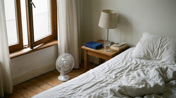Schlafzimmer mit offenem Fenster und Ventilator, besser schlafen bei warmem Wetter