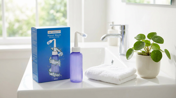 Comformidable Nasendusche mit Verpackung auf dem Rand eines Waschbeckens in einem hellen Badezimmer