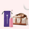 Bidetflasche neben dem lila Comformidable-Aufbewahrungsbeutel und einer Reisetasche