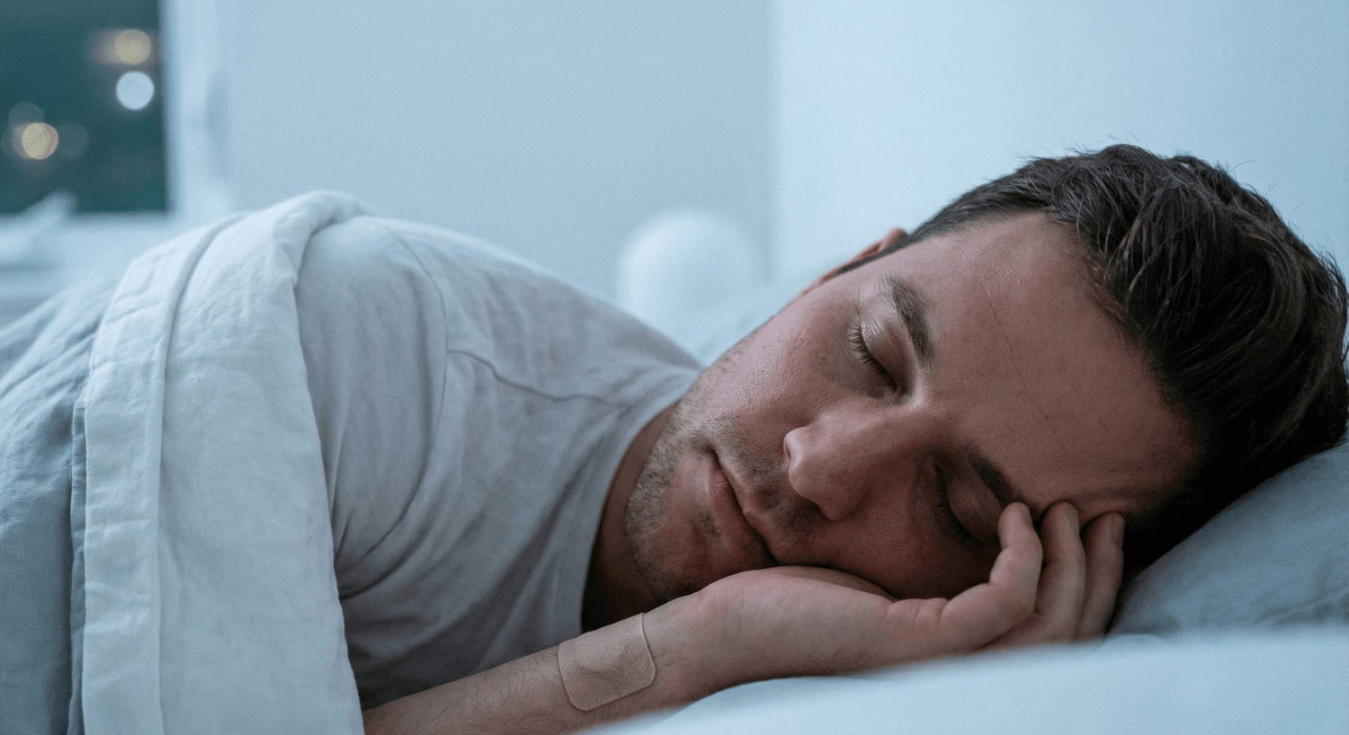 Slapende man met een slaappleister zichtbaar op zijn arm