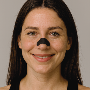 Portret van een vrouw die recht in de camera kijkt met een zwarte neusstrip